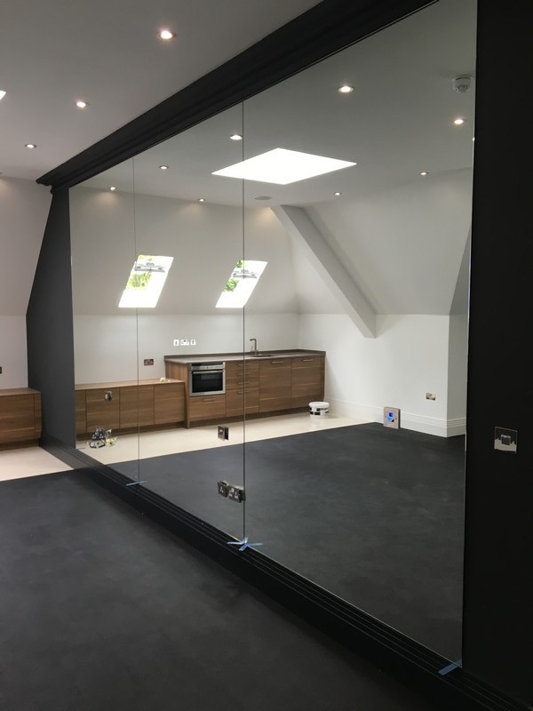 Frameless glass partition in loft conversion by Waltham Cross glaziers